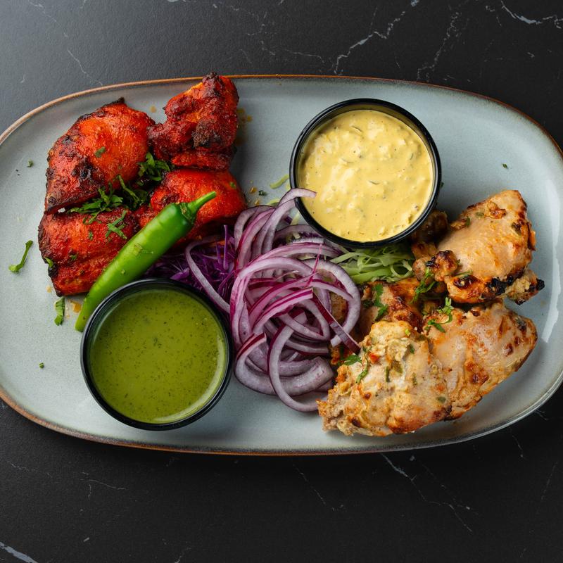 Marinated chicken with veggies and dipping sauces.