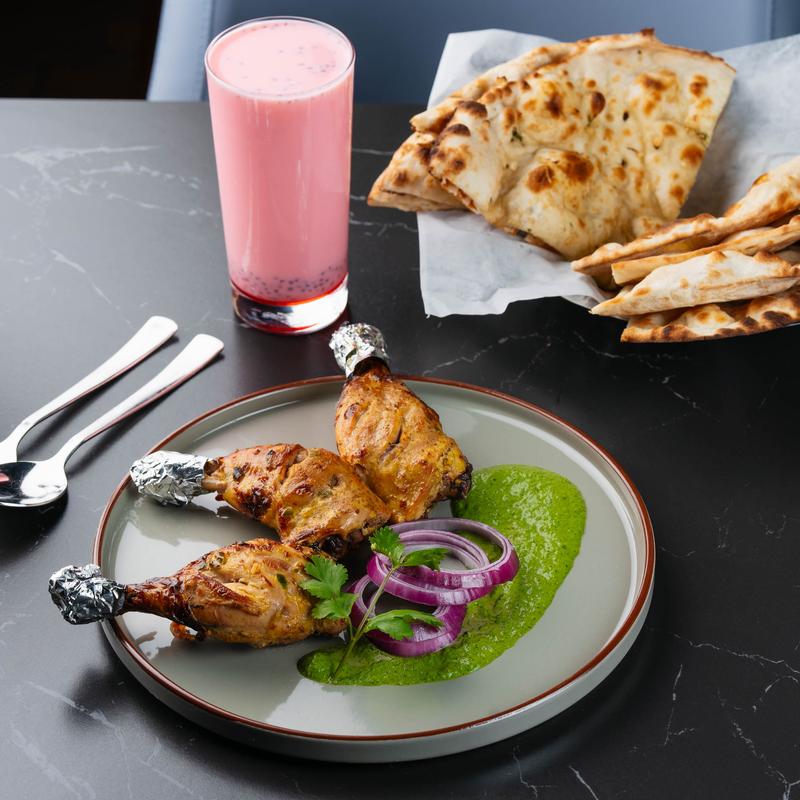 Marinated chicken drumsticks, naan bread, and Rose Milk.